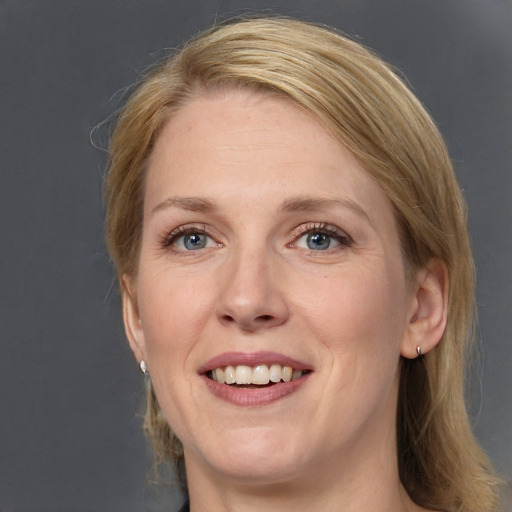 Joyful white adult female with medium  brown hair and blue eyes