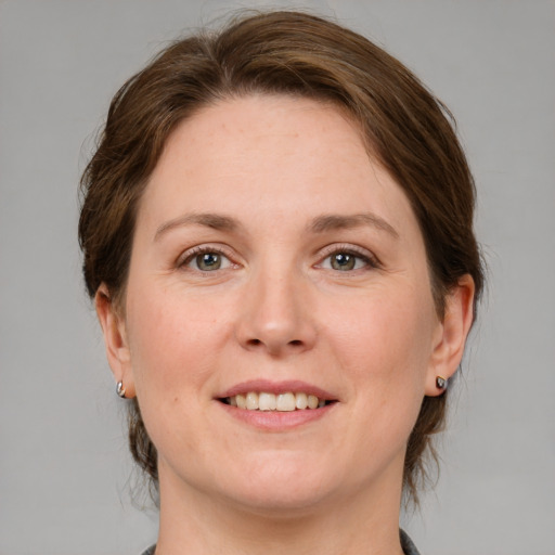 Joyful white adult female with medium  brown hair and grey eyes