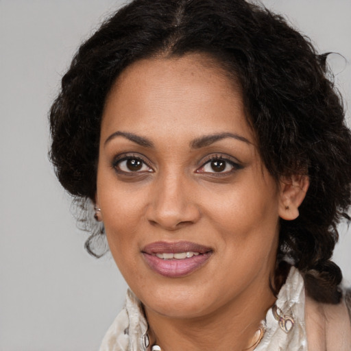 Joyful black adult female with long  brown hair and brown eyes