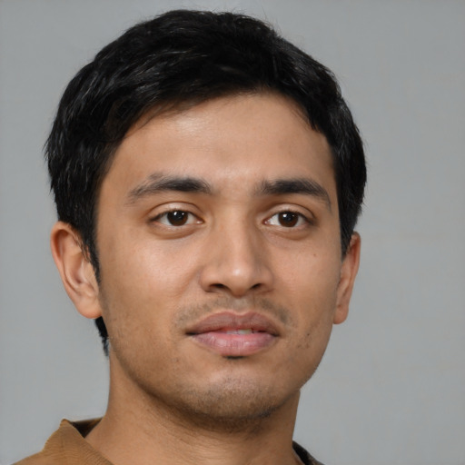 Joyful latino young-adult male with short  black hair and brown eyes