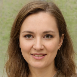 Joyful white young-adult female with long  brown hair and green eyes