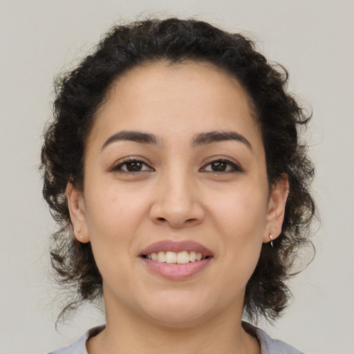 Joyful latino young-adult female with medium  brown hair and brown eyes