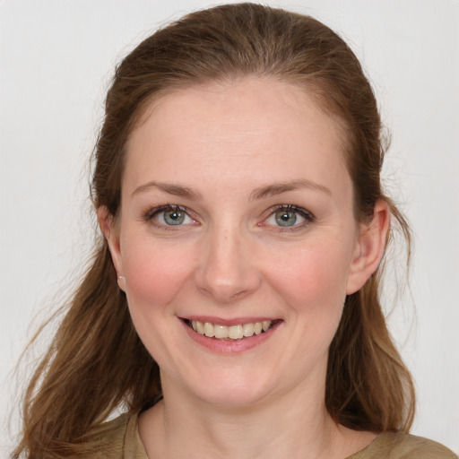 Joyful white young-adult female with medium  brown hair and green eyes