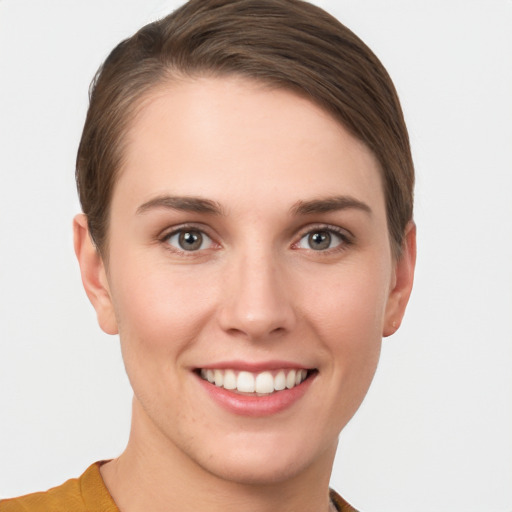 Joyful white young-adult female with short  brown hair and grey eyes