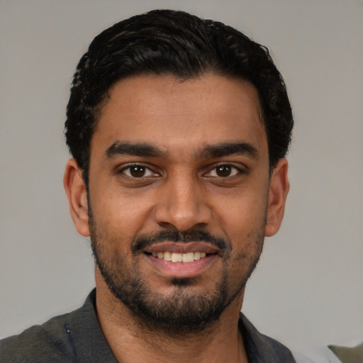 Joyful latino young-adult male with short  black hair and brown eyes