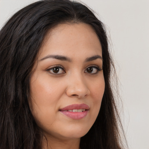 Joyful latino young-adult female with long  brown hair and brown eyes