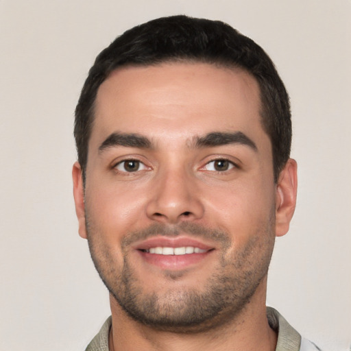 Joyful white young-adult male with short  black hair and brown eyes