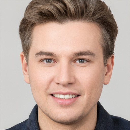 Joyful white young-adult male with short  brown hair and grey eyes