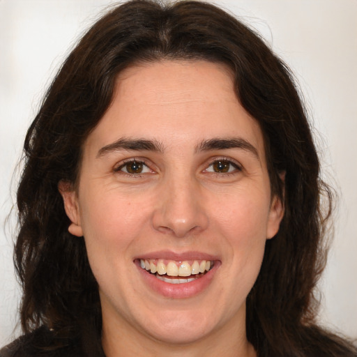 Joyful white adult female with long  brown hair and brown eyes