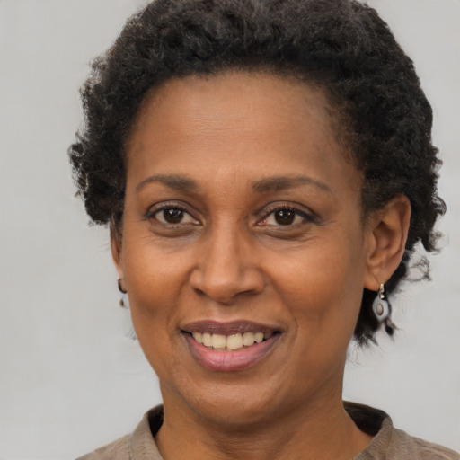 Joyful black adult female with short  brown hair and brown eyes