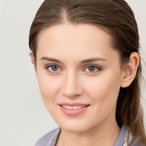 Joyful white young-adult female with long  brown hair and blue eyes