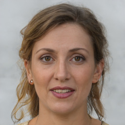 Joyful white adult female with medium  brown hair and grey eyes