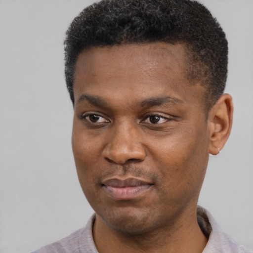 Joyful black young-adult male with short  black hair and brown eyes