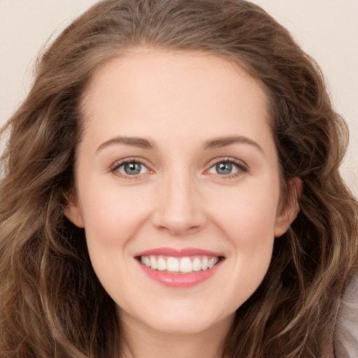 Joyful white young-adult female with long  brown hair and green eyes