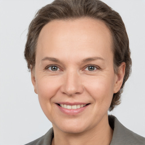 Joyful white adult female with short  brown hair and grey eyes