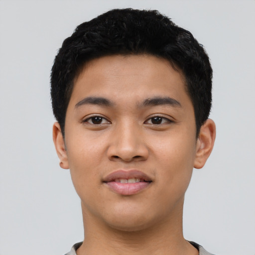 Joyful latino young-adult male with short  black hair and brown eyes
