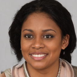 Joyful black young-adult female with long  brown hair and brown eyes