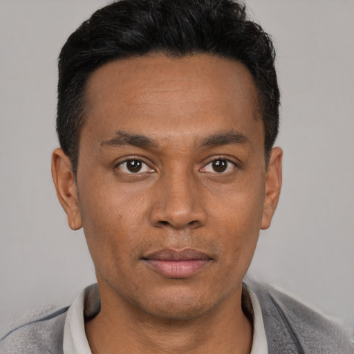 Joyful latino young-adult male with short  black hair and brown eyes