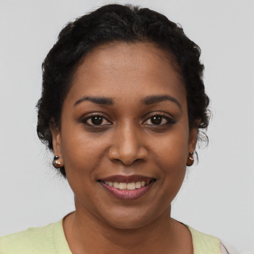 Joyful black young-adult female with short  brown hair and brown eyes