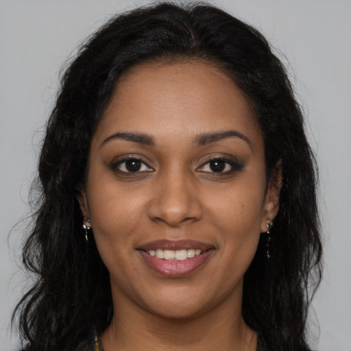 Joyful black young-adult female with long  brown hair and brown eyes
