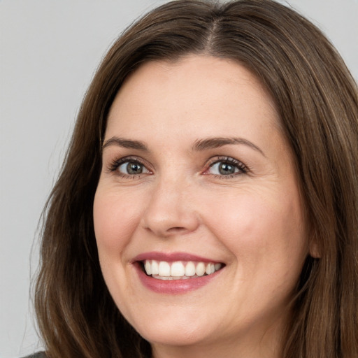 Joyful white adult female with long  brown hair and brown eyes