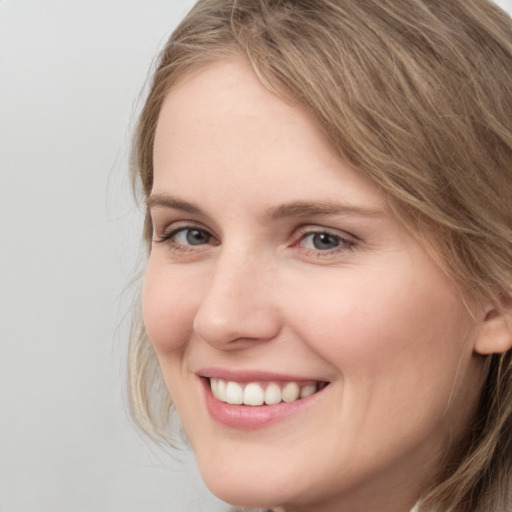 Joyful white young-adult female with long  brown hair and grey eyes