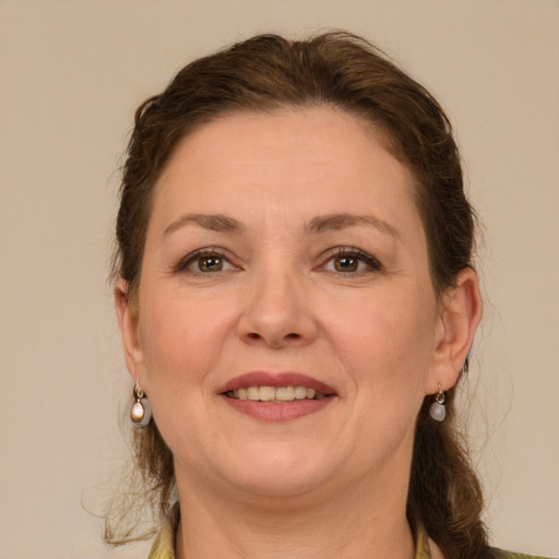 Joyful white adult female with medium  brown hair and green eyes