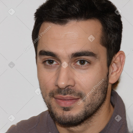 Joyful white young-adult male with short  black hair and brown eyes