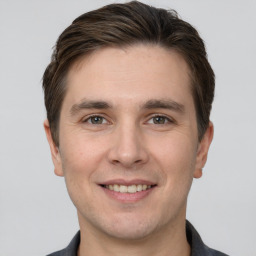 Joyful white young-adult male with short  brown hair and grey eyes