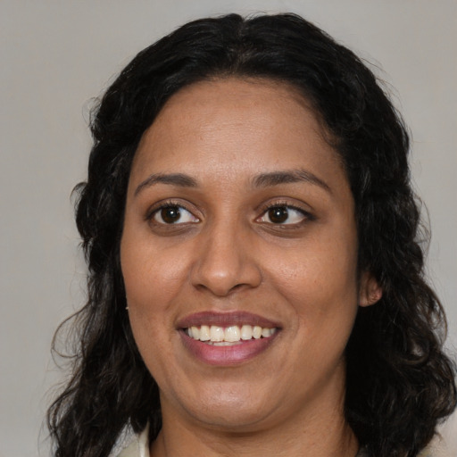 Joyful latino adult female with medium  black hair and brown eyes