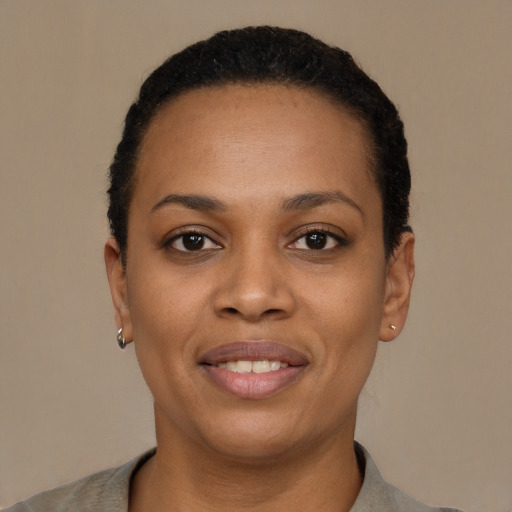 Joyful black young-adult female with short  black hair and brown eyes