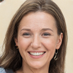 Joyful white adult female with long  brown hair and grey eyes