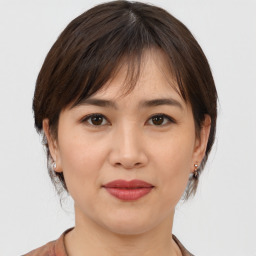 Joyful asian young-adult female with medium  brown hair and brown eyes