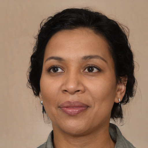 Joyful latino adult female with medium  brown hair and brown eyes