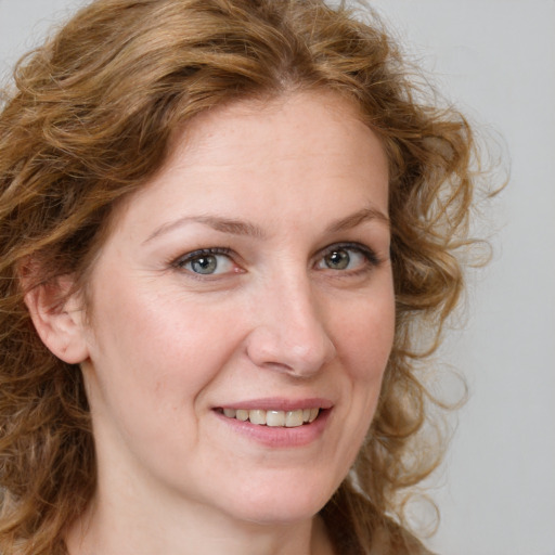 Joyful white adult female with long  brown hair and blue eyes