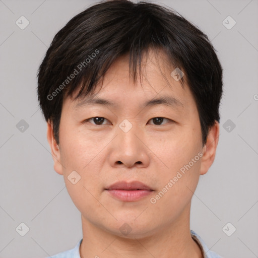 Joyful asian young-adult male with short  brown hair and brown eyes