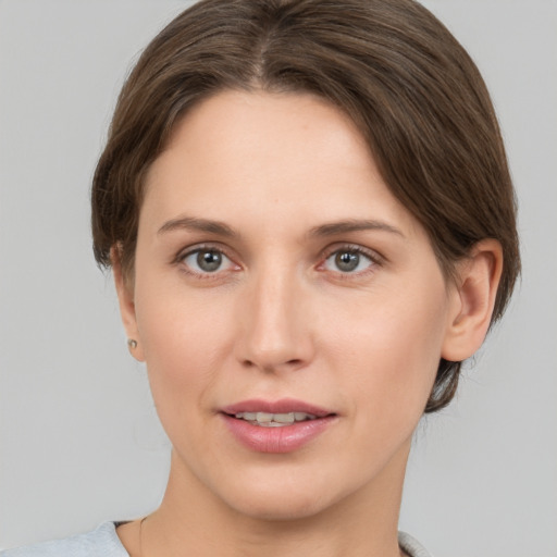 Joyful white young-adult female with medium  brown hair and grey eyes