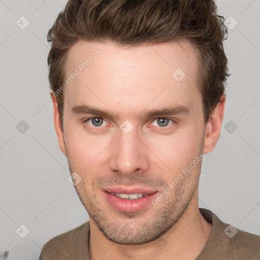 Joyful white young-adult male with short  brown hair and grey eyes