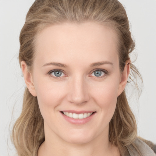 Joyful white young-adult female with long  brown hair and grey eyes