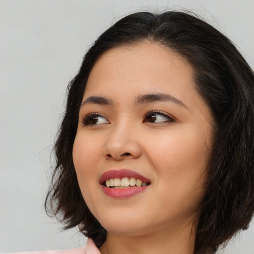 Joyful asian young-adult female with long  brown hair and brown eyes