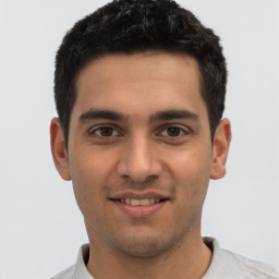 Joyful white young-adult male with short  black hair and brown eyes