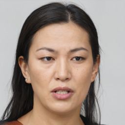 Joyful asian adult female with medium  brown hair and brown eyes