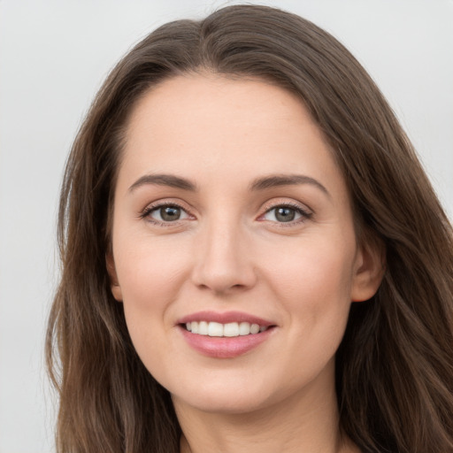 Joyful white young-adult female with long  brown hair and grey eyes