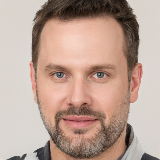 Joyful white adult male with short  brown hair and grey eyes