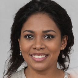 Joyful black young-adult female with long  brown hair and brown eyes