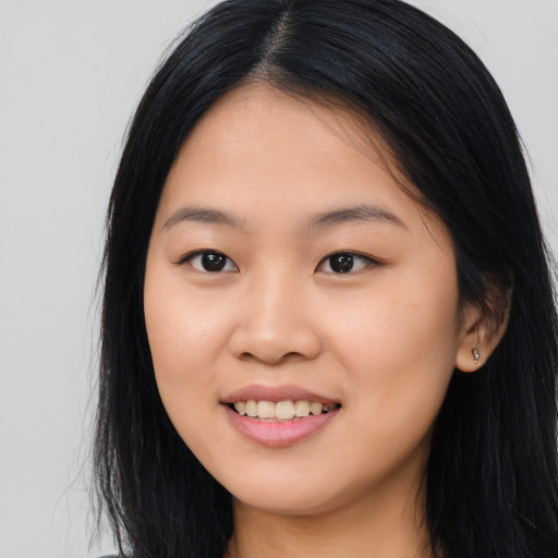 Joyful asian young-adult female with long  black hair and brown eyes