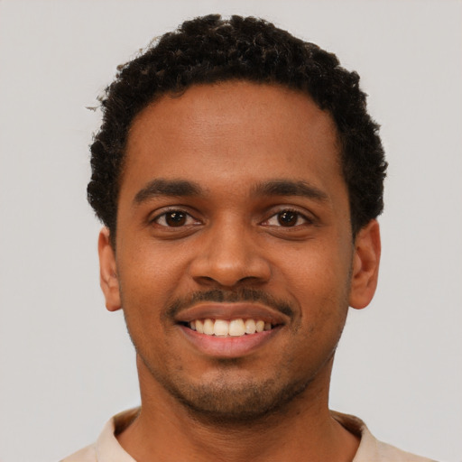 Joyful black young-adult male with short  black hair and brown eyes