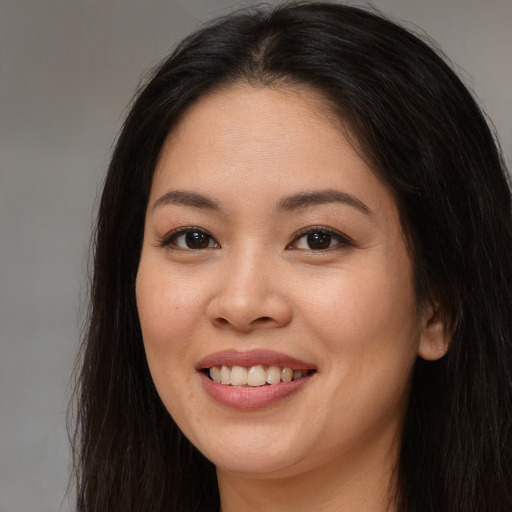 Joyful asian young-adult female with long  brown hair and brown eyes