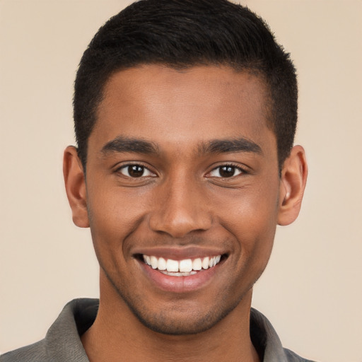 Joyful black young-adult male with short  brown hair and brown eyes