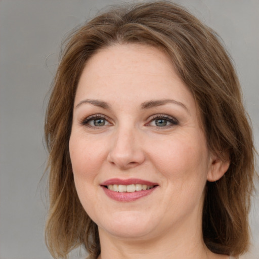 Joyful white adult female with medium  brown hair and grey eyes